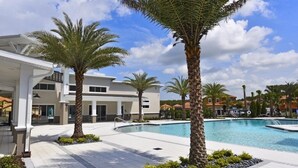 A modern hotel with a swimming pool, palm trees, and a clear blue sky. - Luxurious 6bd Pool Haven Refreshing And Chic-4464n 6 Bedroom Home by RedAwning (Kissimmee)
