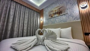 A hotel room with a bed, a wall-mounted light fixture, and a decorative wall piece. - Gold Sky Avenue Hotel (Dubai)