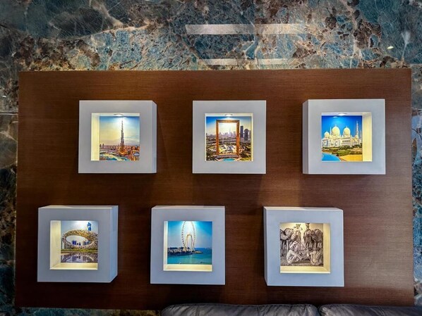 A wall with six framed pictures depicting various cityscapes and landmarks.