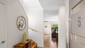 Un intérieur moderne avec un banc en bois, un vase décoratif et un tableau encadré au mur.