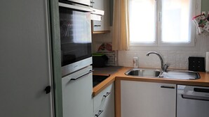 Eine kompakte Küche mit Backofen, Spüle und Geschirrspüler.