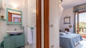 Un baño con un lavamanos grande, un espejo y una toalla colgada en la pared.