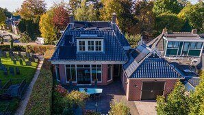 A house with a sloped roof, a conservatory, and a garden with a pathway. - Characteristic House With Wellness in Augustinusga (Augustinusga)