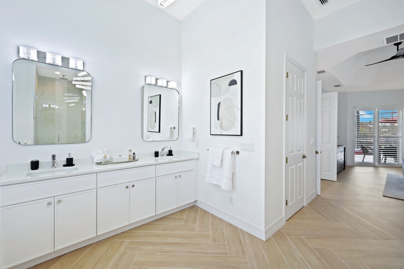 Une salle de bain moderne dotée d’un grand miroir, de deux lavabos et d’une douche à l’italienne.