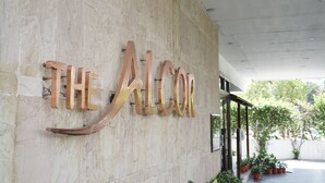 A building facade with the name 'THE ALCOR' in large, metallic letters. - ALCOR HOTEL JAMSHEDPUR (Golmuri)