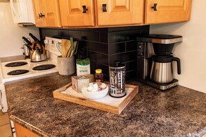 Eine Küchenarbeitsplatte mit Kaffeemaschine, Wasserkocher und einer Schüssel voller Zutaten.