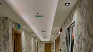 A hotel corridor with patterned walls, a marble floor, and doors leading to rooms. - Tamarind Hotel (Dubai)