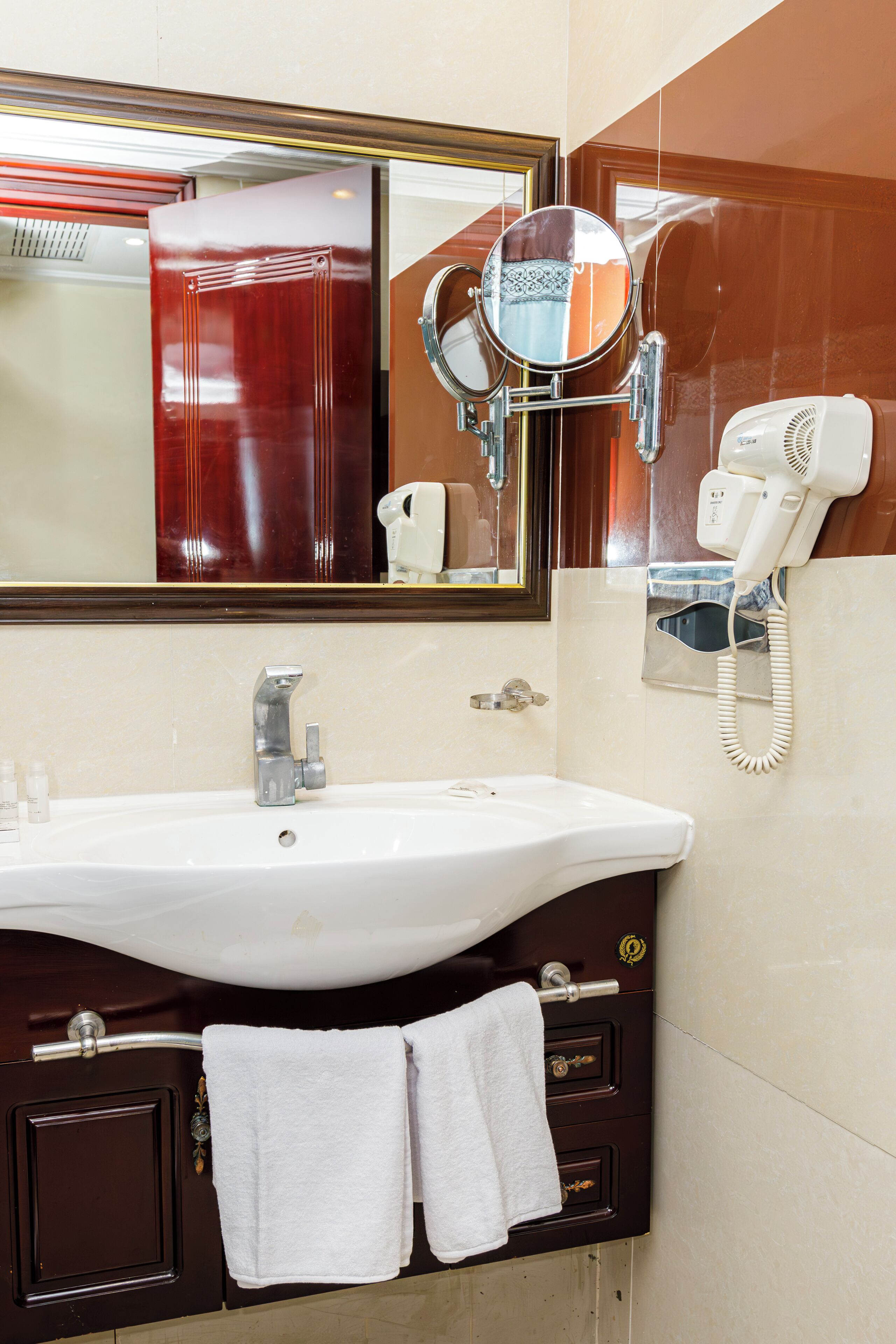 Baño con lavamanos, espejo y secador de pelo.