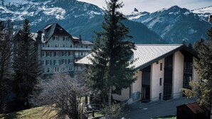 A hotel with a traditional European architectural style, featuring a prominent building with multiple windows and a sloped roof.