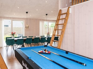 A pool table with a ladder, green chairs, and a dining area with a table and chairs. - 14 Person Holiday Home in Glesborg (Glesborg)