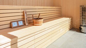 A sauna with wooden benches, a wooden bucket, and a thermometer. - 14 Person Holiday Home in Glesborg (Glesborg)