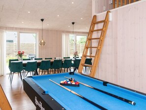 A pool table with a wooden ladder, green chairs, and a dining area with a table and chairs. - 14 Person Holiday Home in Glesborg (Glesborg)