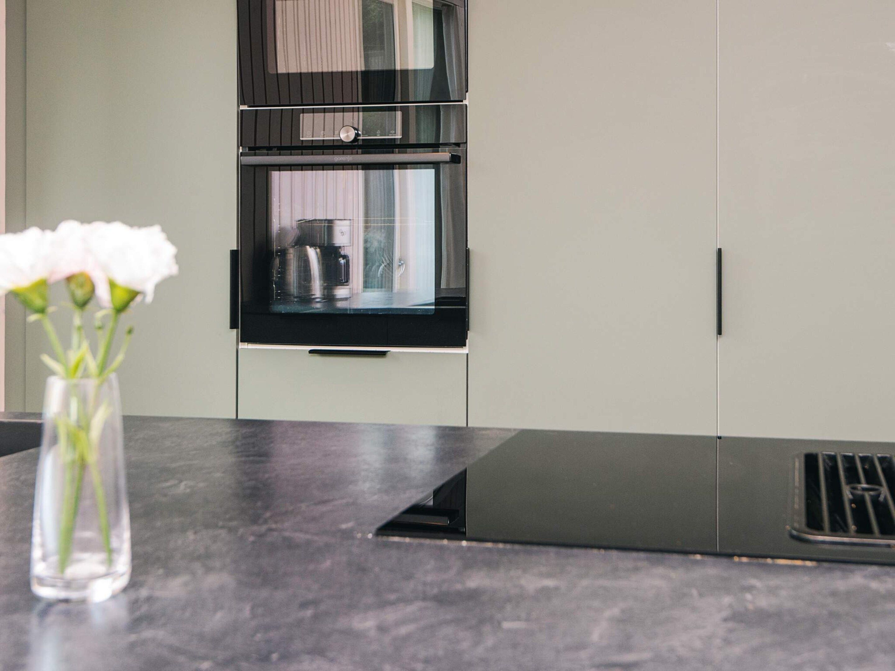 A kitchen with a built-in oven and a coffee maker on the counter.