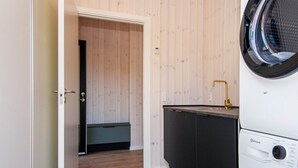 A compact laundry room with a washing machine, a dryer, and a small sink. - 14 Person Holiday Home in Glesborg (Glesborg)