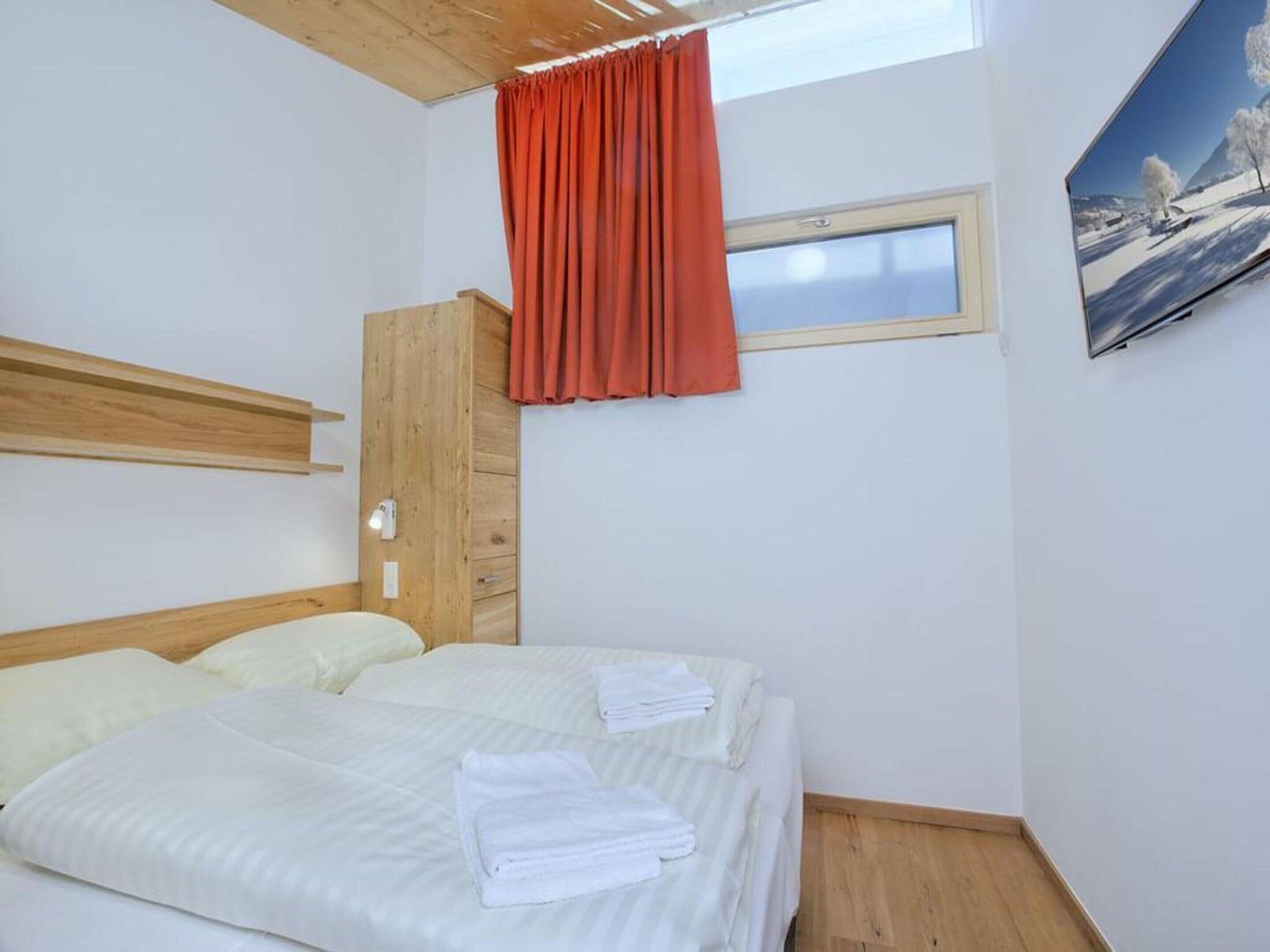 Une chambre à coucher avec un lit, une fenêtre, une porte et un tableau au mur.
