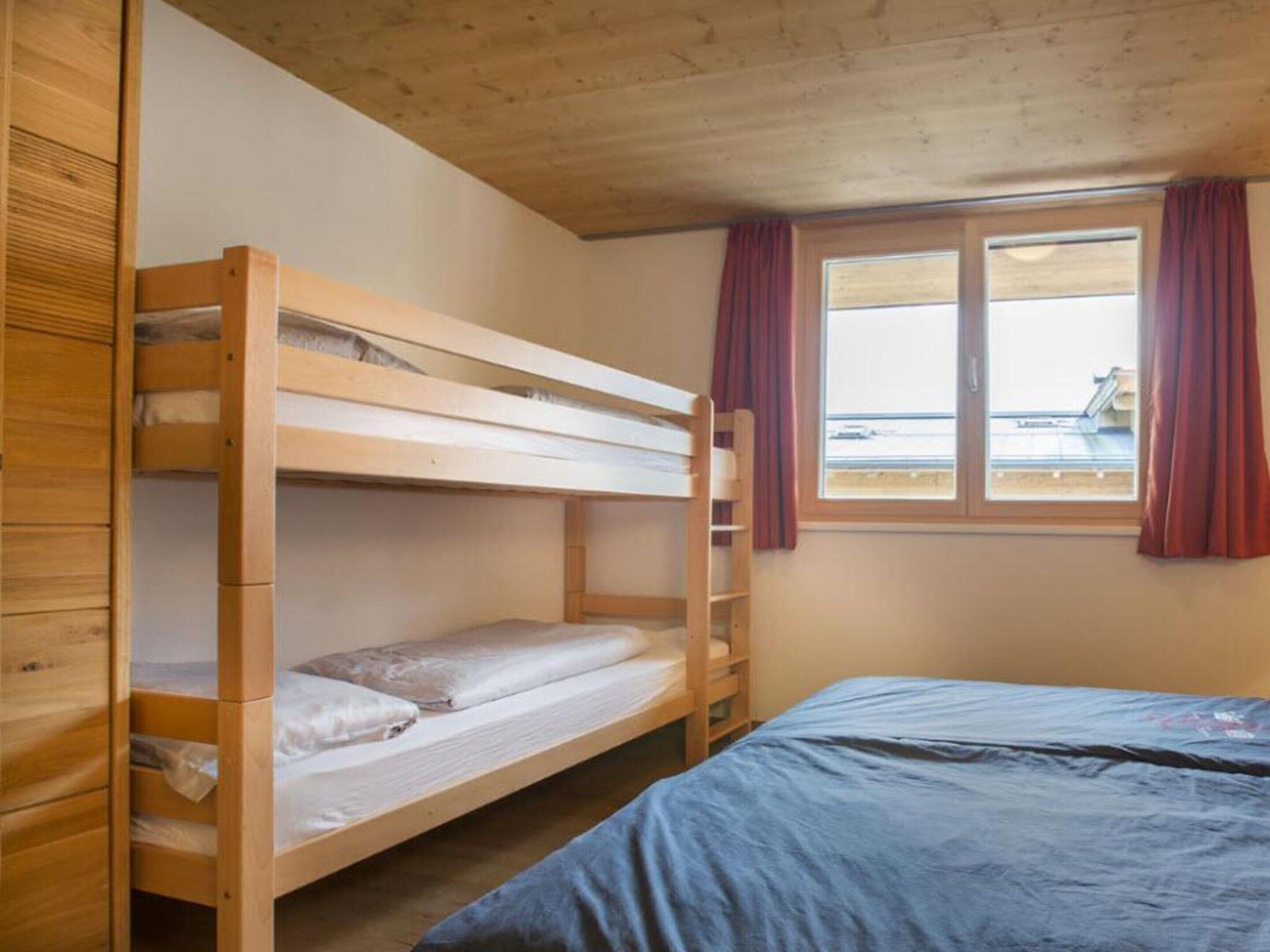 Habitación con literas, ventana y cortinas.