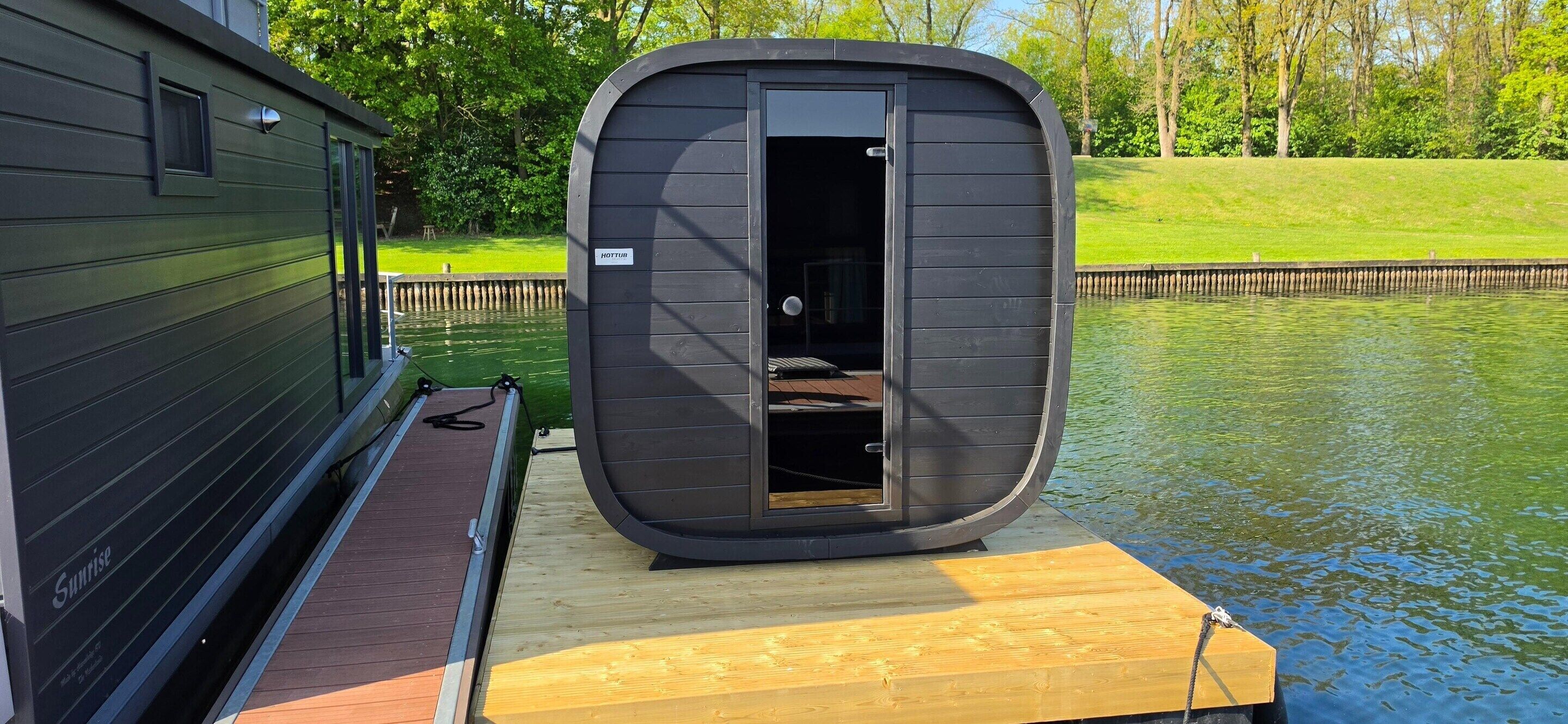 Una casa rodante flotante, con una pequeña cabina cerrada sobre una plataforma de madera.