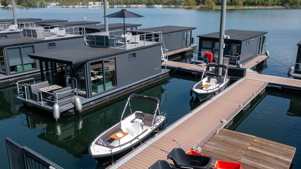 A marina with modern floating homes, each with a covered deck and outdoor seating. - Houseboat Mookerplas With a View (Middelaar)