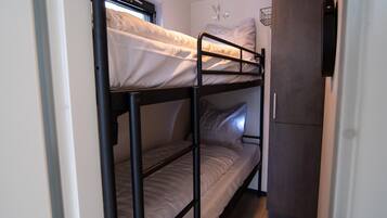 A bunk bed room with a small kitchenette area.