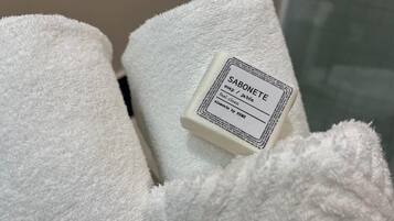 A white towel with a label that reads "SABONETE soap / jabón" and "feel clean / se siente limpio."