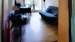 A room with a dining table and chairs, a sofa, and a lamp. - Le Moulleau Ctre, Front de Mer, Studio 2 Personnes Avec Terrasse (Arcachon)