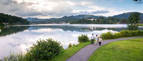 A lake with a walking path and a few people walking.