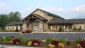 A building with a stone facade, a large entrance, and a parking lot. - Hillside Lodge (Lake Junaluska)