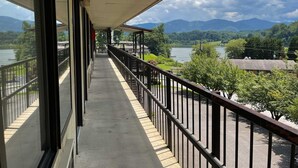 A balcony with a view of a lake and mountains. - Hillside Lodge (Lake Junaluska)