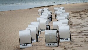 Rows of white beach chairs with numbers on them, arranged on a sandy beach near the ocean. - Holiday Home Reet-seaside (Glowe)
