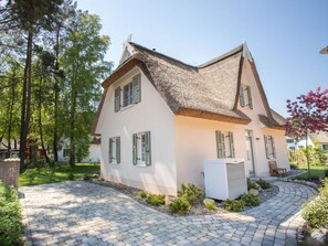 A two-story house with a thatched roof, white exterior walls, and green shutters. - Holiday Home Reet-seaside (Glowe)