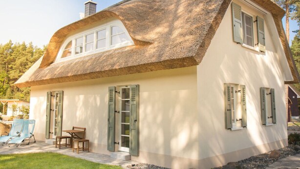 A traditional house with a thatched roof, white walls, and green shutters. - Holiday Home Reet-seaside (Glowe)