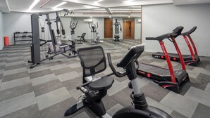 A gym with treadmills, exercise bikes, and weight machines.