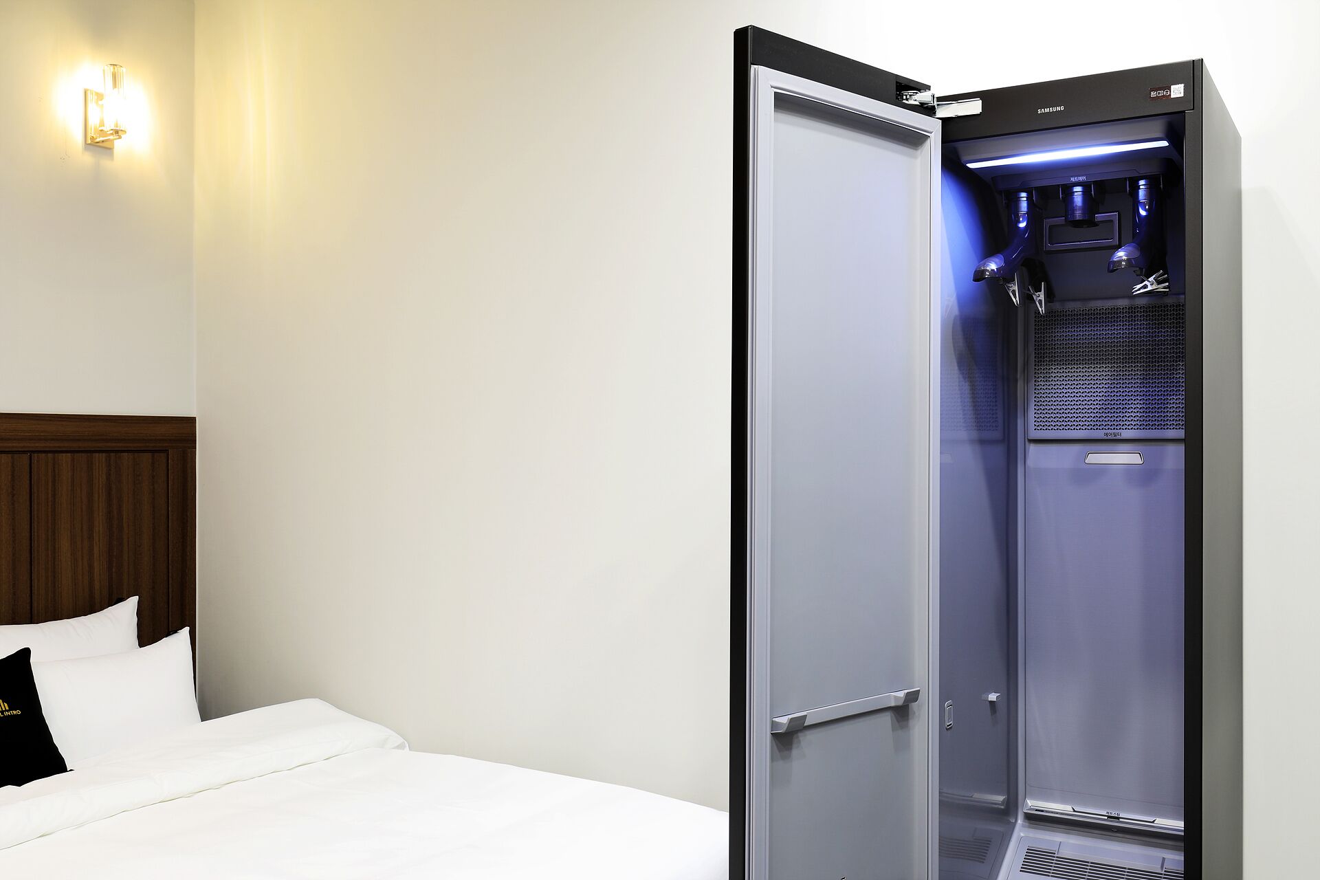 Una camera d'albergo con un letto, un armadio e uno spazio doccia integrato.