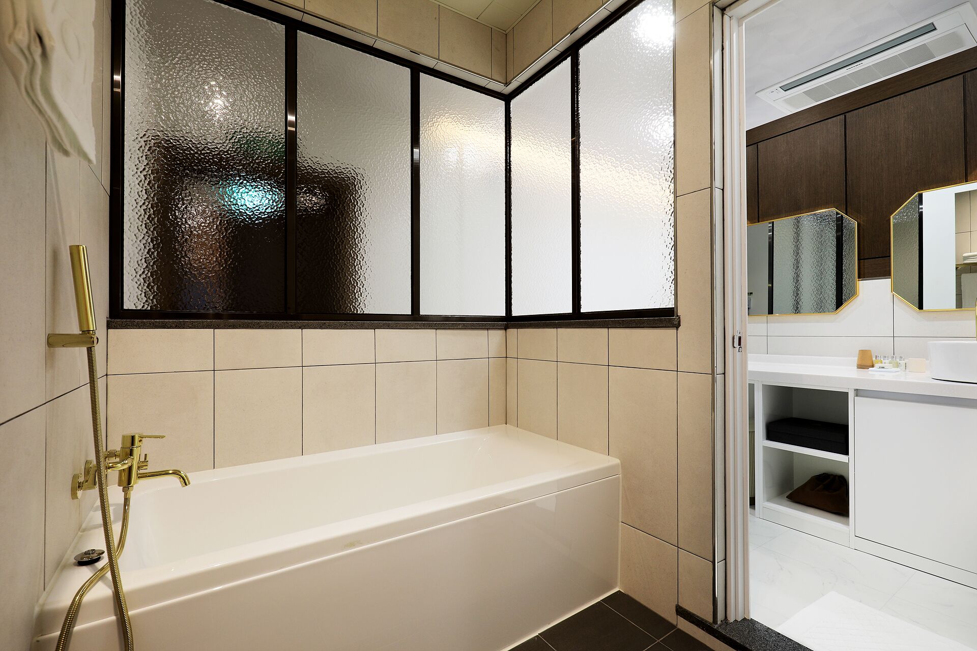 A modern bathroom with a bathtub, a glass shower enclosure, and a vanity with a mirror.