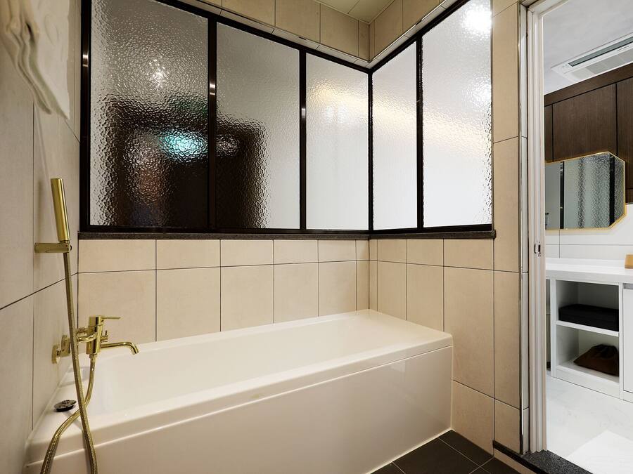 A modern bathroom with a bathtub, a glass shower enclosure, and a vanity with a mirror.