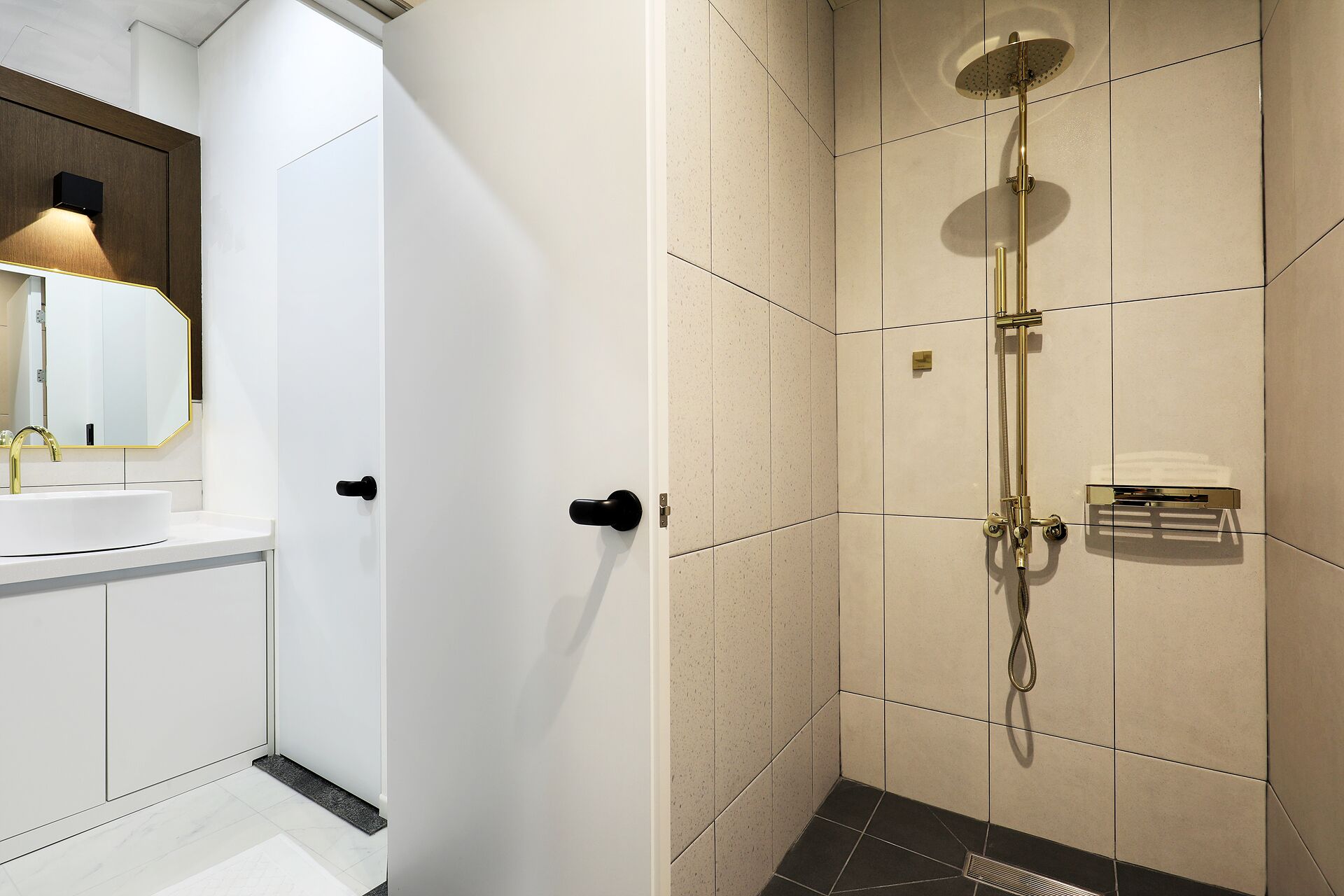 A modern bathroom with a white sink, a mirror, and a shower with a handheld showerhead.