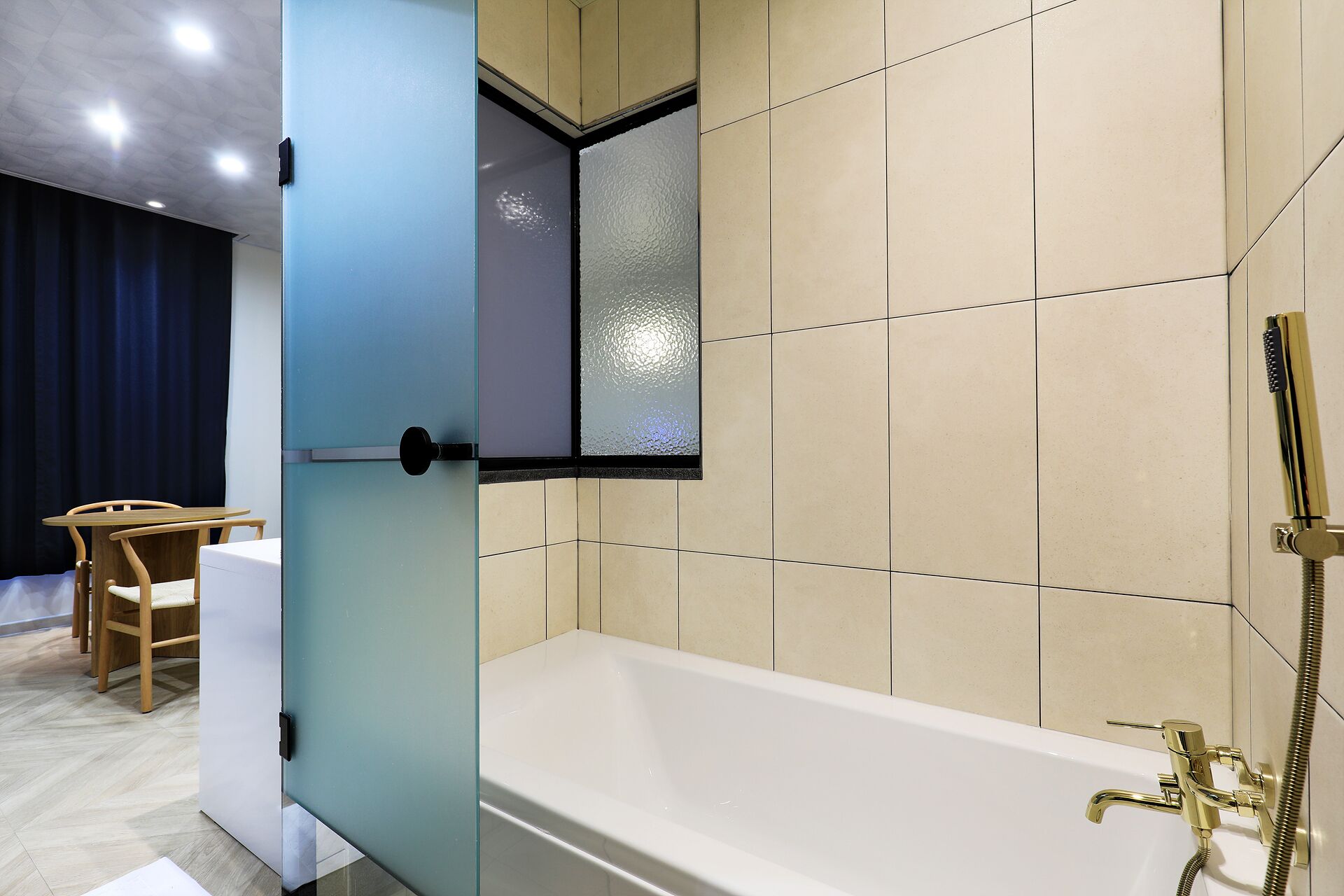 A modern bathroom with a bathtub, a shower, and a glass-enclosed vanity.