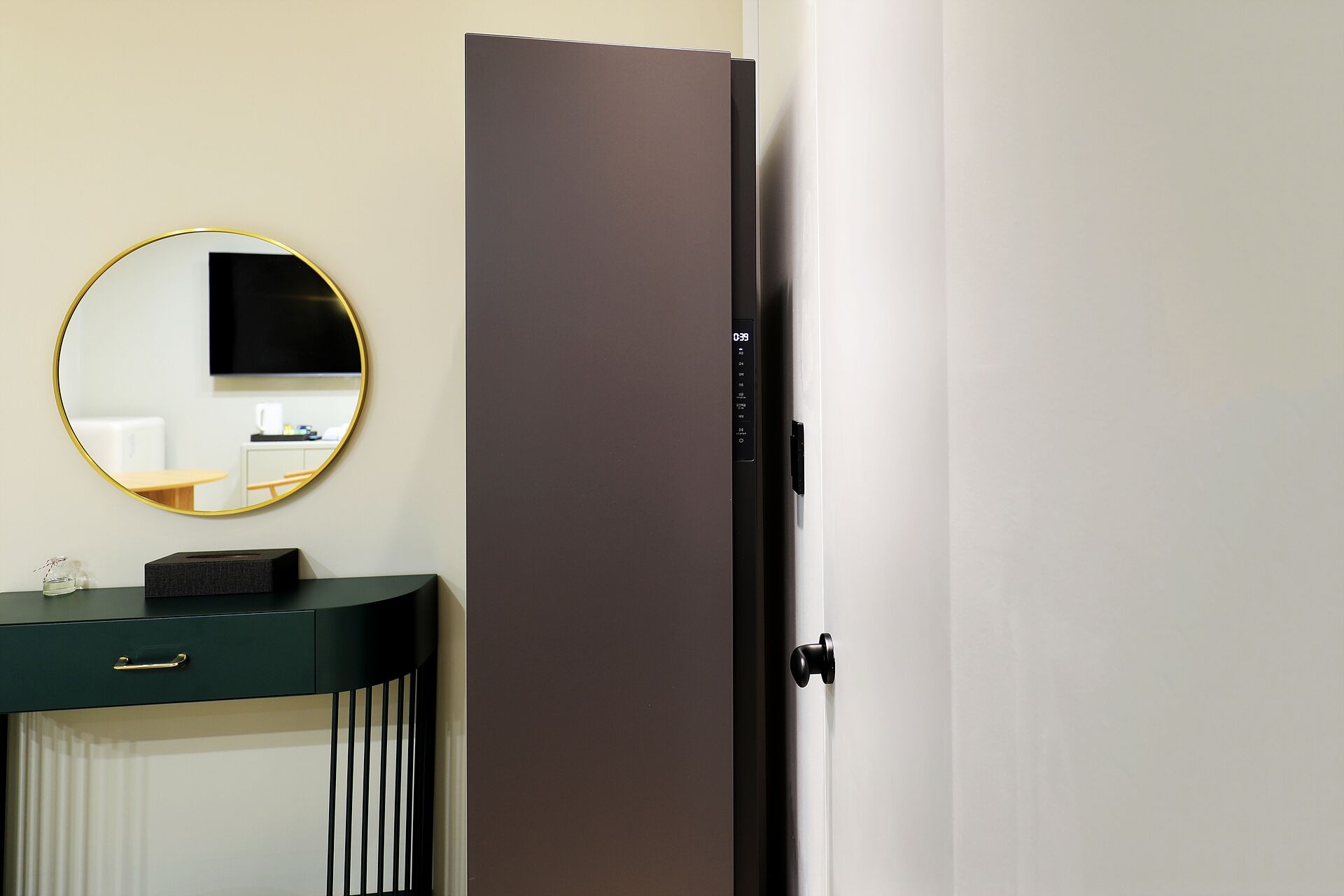 A modern bathroom with a dark vanity, a round mirror, and a toilet.