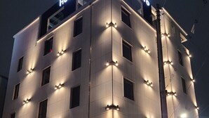 A hotel building with illuminated signage reading "Hotel Intro" at the top.