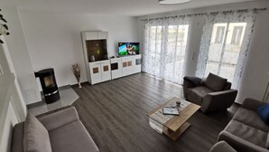 Ein modernes Wohnzimmer mit einer Sofagarnitur, einem Couchtisch, einem Fernseher und einem Kamin.