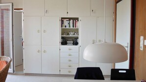 A room with a white wardrobe, a table with chairs, and a lamp. - Near the Beach Modern Retreat (Wangerooge)