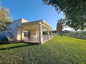 A modern house with a covered patio, a staircase, and a well-maintained lawn. - Holiday Home in Leonforte With Private Pool (Leonforte)