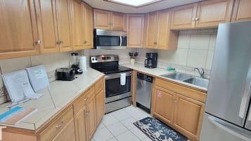 Condo, várias camas, sacada, vista parcial para o mar (Aquarius 408) | Cozinha privada | Geladeira, micro-ondas, fogão, cooktop
