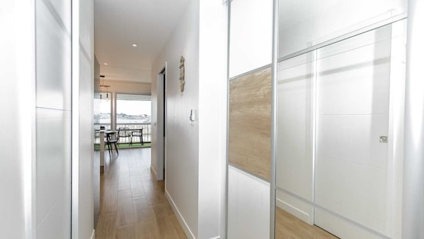A modern hallway with a view to a balcony, wooden flooring, and a glass partition wall. - Appartement VUE MER (Quiberon)