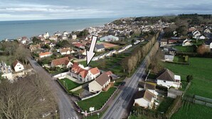 An aerial view of a coastal town with a mix of residential houses and a prominent church steeple.