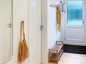 A hallway with a bench, a door with a frosted glass panel, and a wall-mounted towel rack. - 6 Person Holiday Home in Stubbekobing (Stubbekobing)