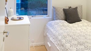 Una camera da letto con un letto, un comodino, una finestra e vista sull'esterno.