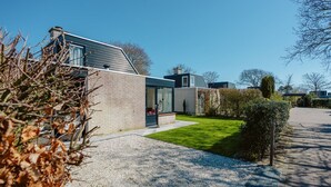 Una casa moderna con un césped cuidado y un camino de entrada de grava.