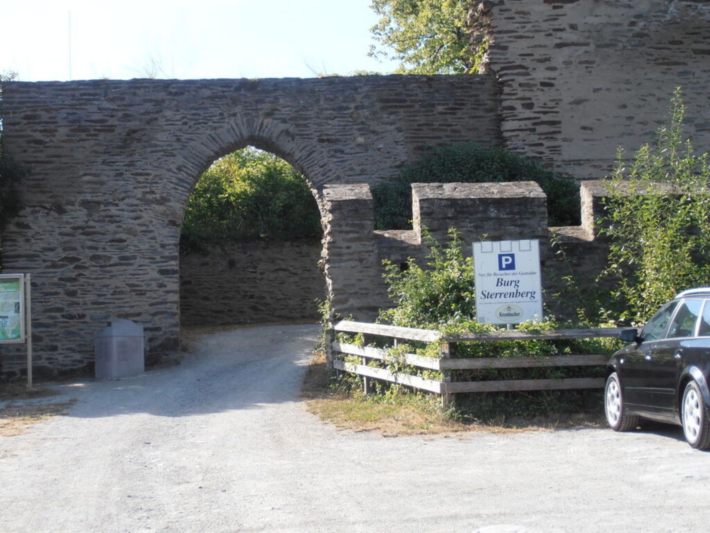 A stone bridge with a sign indicating a parking area for Burg Sterrenberg.