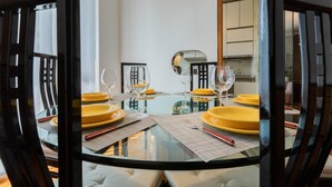 A modern dining area with a glass table, yellow plates, and wine glasses. - Villetta con Giardino Allo Stadio by Wonderful Italy (Turin)